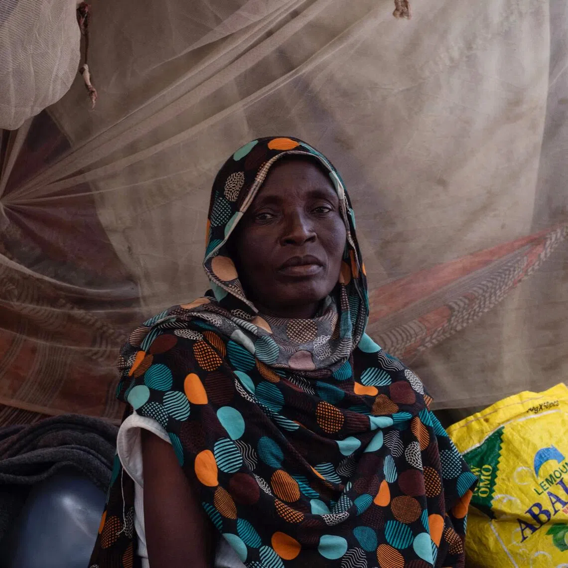 A Sudanese woman who fled El-Fasher after the city fell to rebel forces sits inside a makeshift shelter in Sudan’s western Darfur region.
