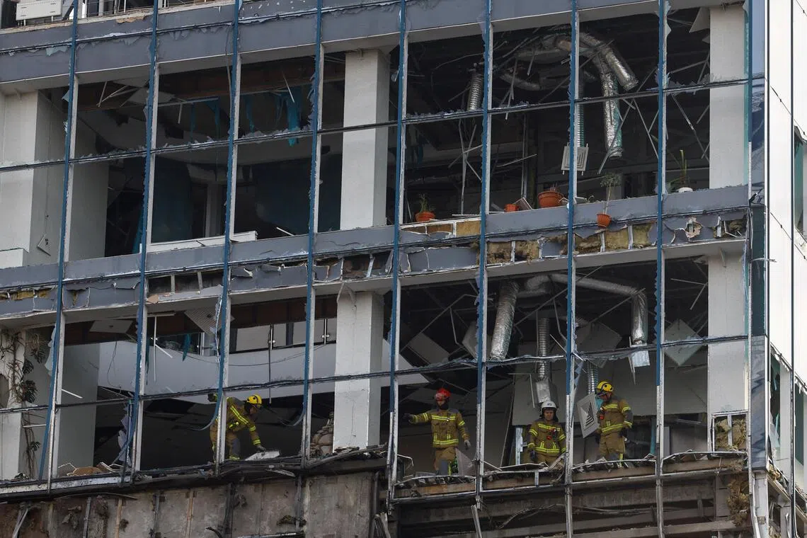 Rescuers working at an office building hit by a Russian drone, in Kyiv, Ukraine, on Sept 25.