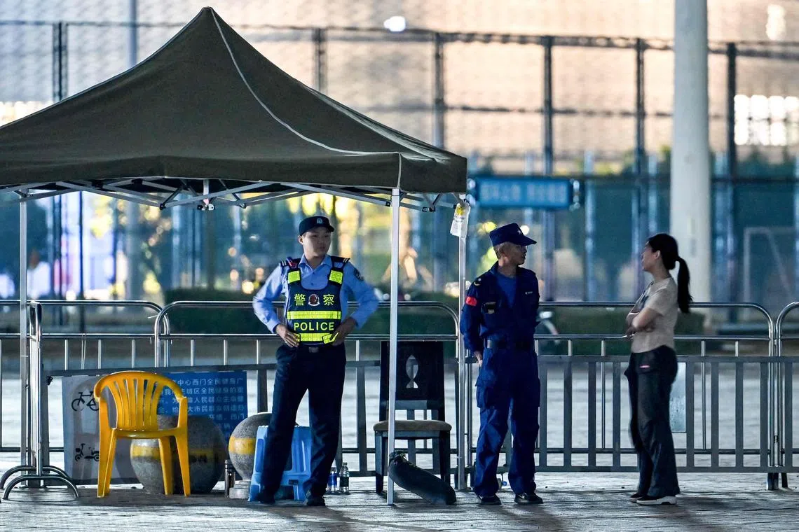 A police personnel stands guard at the Zhuhai Sports Centre, a day after a car rammed through the site killing 35 people and wounding 43.