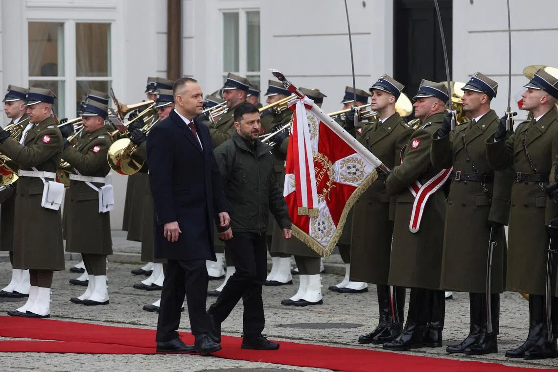 FILE PHOTO: Polish President Karol Nawrocki and Ukrainian President Volodymyr Zelenskiy inspect a guard of honour during a welcoming ceremony at the courtyard of the Presidential Palace in Warsaw, Poland, December 19, 2025. REUTERS/Kacper Pempel/File Photo