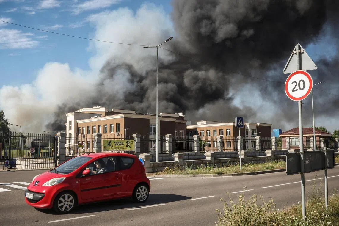 A car passes by a site of a Russian drone strike as smoke rises, amid Russia’s attack on Ukraine, in Kyiv region, Ukraine, Aug 29.