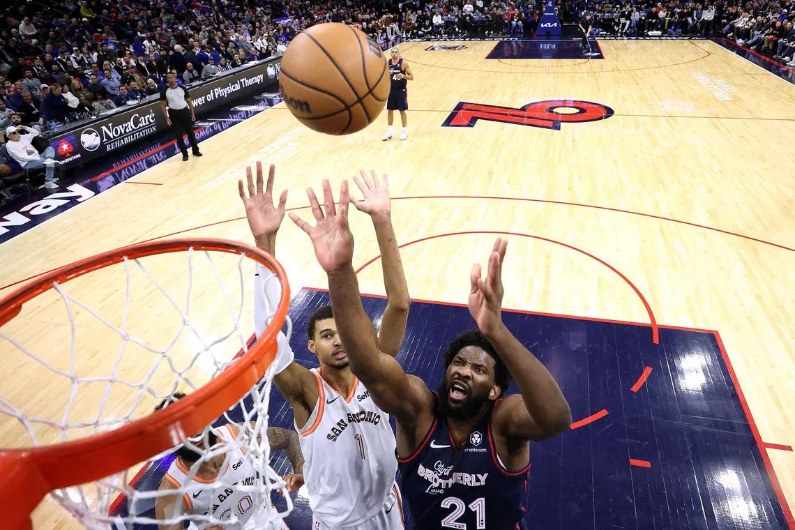 Victor Wembanyama of the San Antonio Spurs and Joel Embiid of the Philadelphia 76ers reach for a rebound during the third quarter at the Wells Fargo Centre.