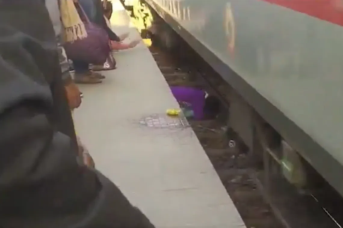 The video showed the woman, in a purple top, crouching protectively over her children as the train whizzes past.