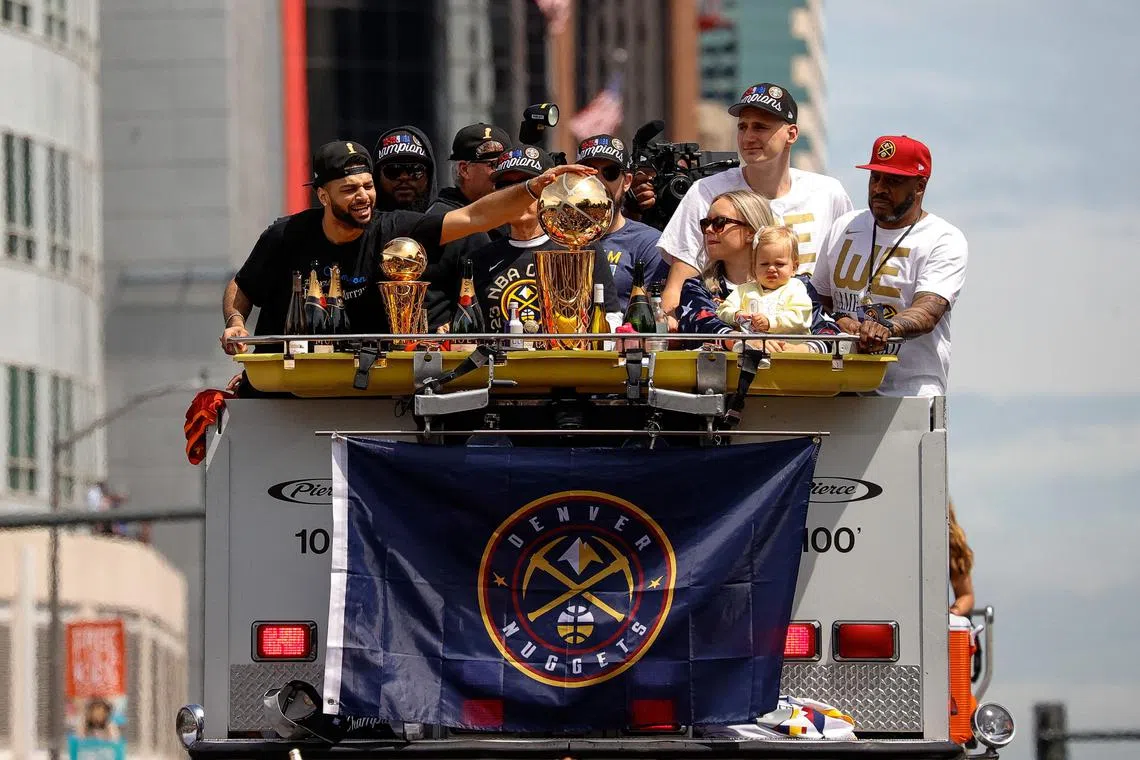 Denver Nuggets guard Jamal Murray (left) touches the Larry O’Brien Championship Trophy as centre Nikola Jokic (right) looks on with his wife Natalija and daughter Ognjena during the championship parade.