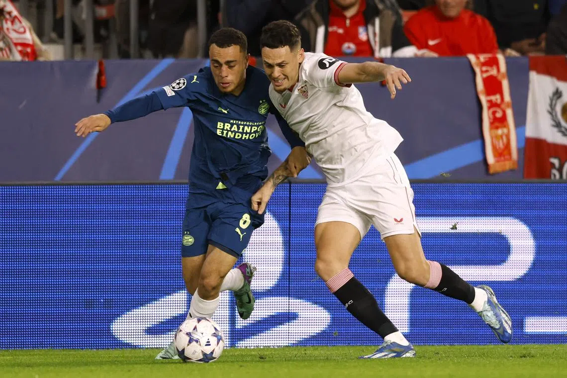 Soccer Football - Champions League - Group B - Sevilla v PSV Eindhoven - Estadio Ramon Sanchez Pizjuan, Seville, Spain - November 29, 2023 PSV Eindhoven's Sergino Dest in action with Sevilla's Lucas Ocampos REUTERS/Marcelo Del Pozo/File Photo