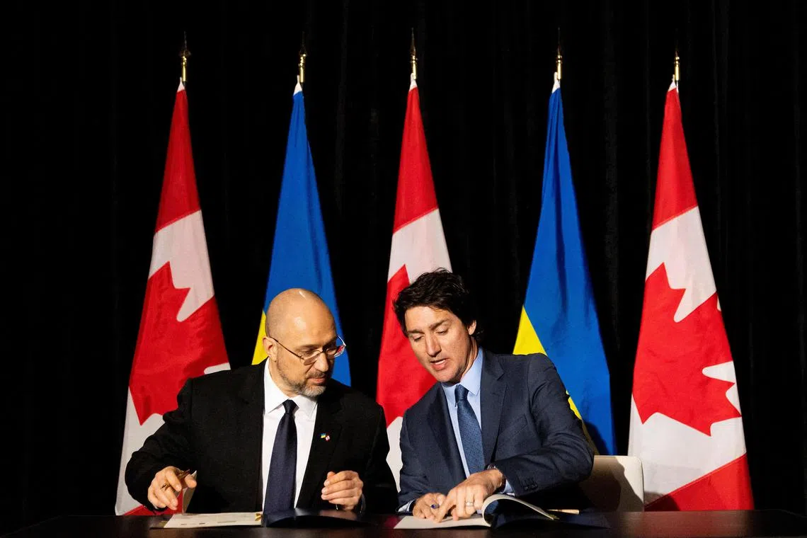 Ukraine’s Prime Minister Denys Shmyhal (left) signs documents  with Canada’s Prime Minister Justin Trudeau in Toronto.