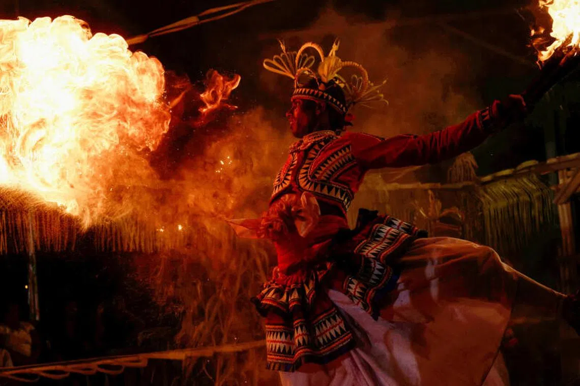A Sri Lankan dancer performs with fire at a Gammaduwa performance, a traditional low country healing ritualistic performance, at a Buddhist temple, in Colombo, Sri Lanka on March 31, 2023. 