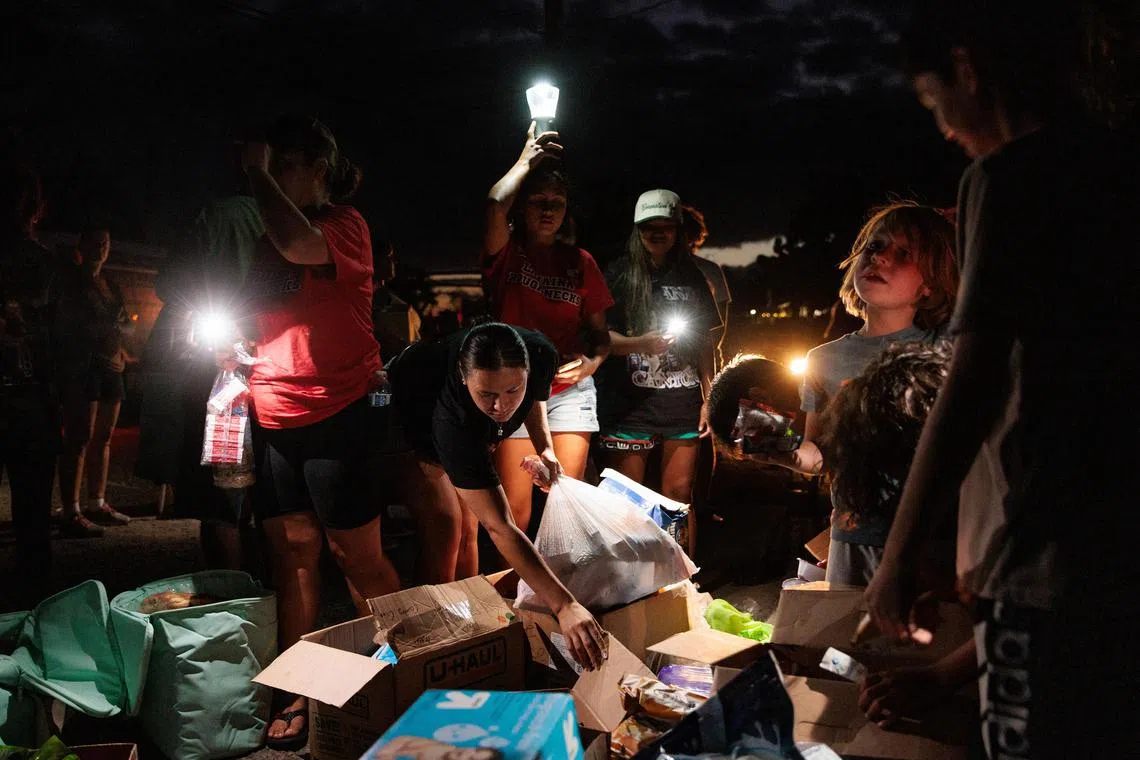 Residents collect food and other supplies delivered by volunteers in Olowalu, Maui, Hawaii, Aug. 12, 2023. (Max Whittaker/The New York Times)