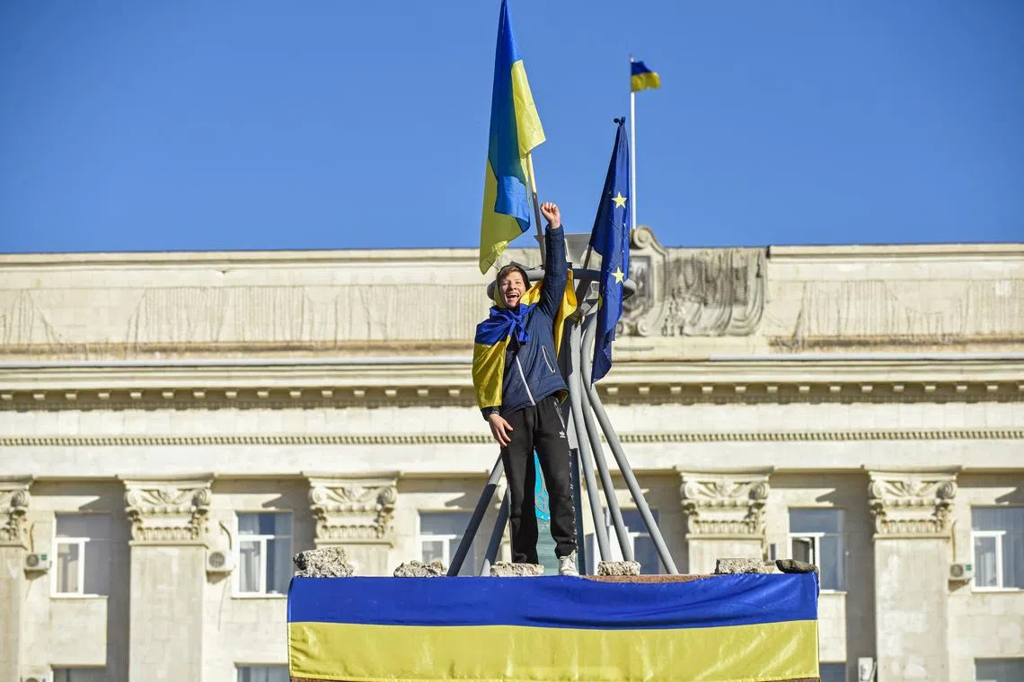 A man cheers during a patriotic rally after President Zelesnky's visit to the recaptured city of Kherson, on Nov 14, 2022. 