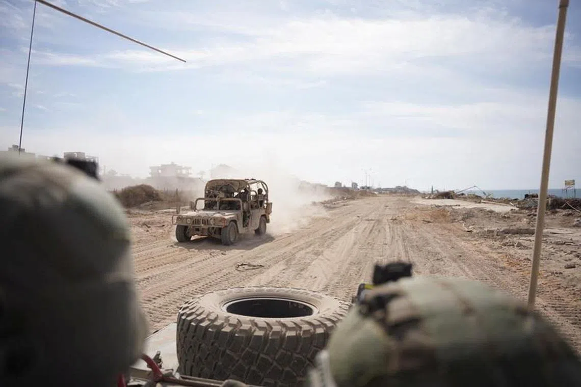 Israeli soldiers drive a military vehicle, amid the ongoing ground operation of the Israeli army against Palestinian Islamist group Hamas, in the Gaza Strip as seen in a handout picture released by the Israel Defense Forces on November 13, 2023. Israel Defense Forces/Handout via REUTERS
