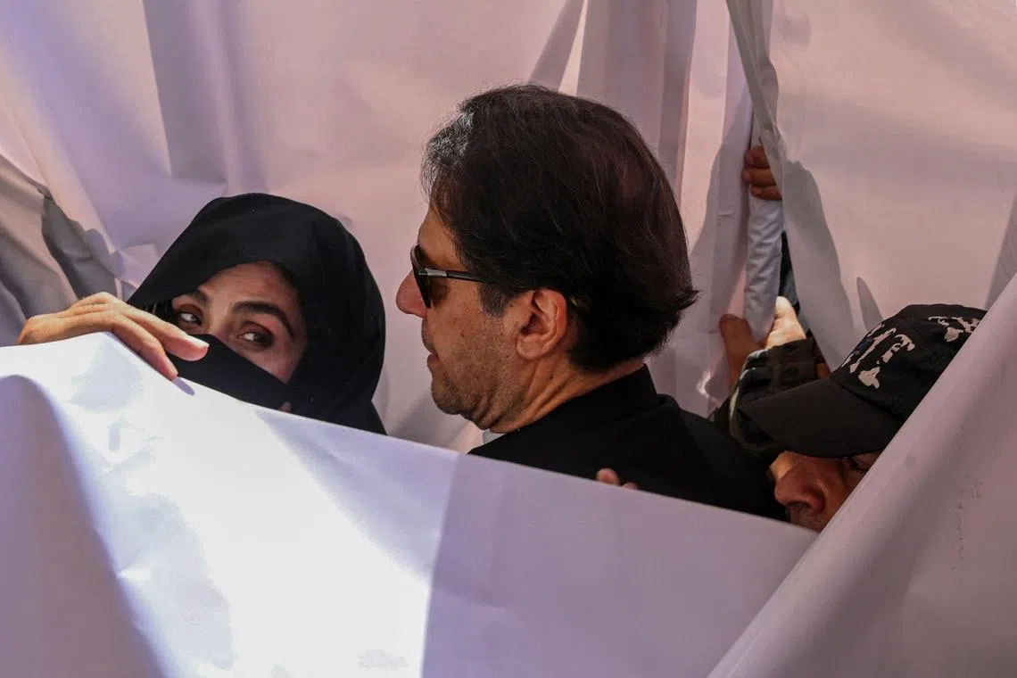 Former Pakistani prime minister Imran Khan and his wife Bushra Bibi are seen arriving in court in this May 15, 2023, file photo.