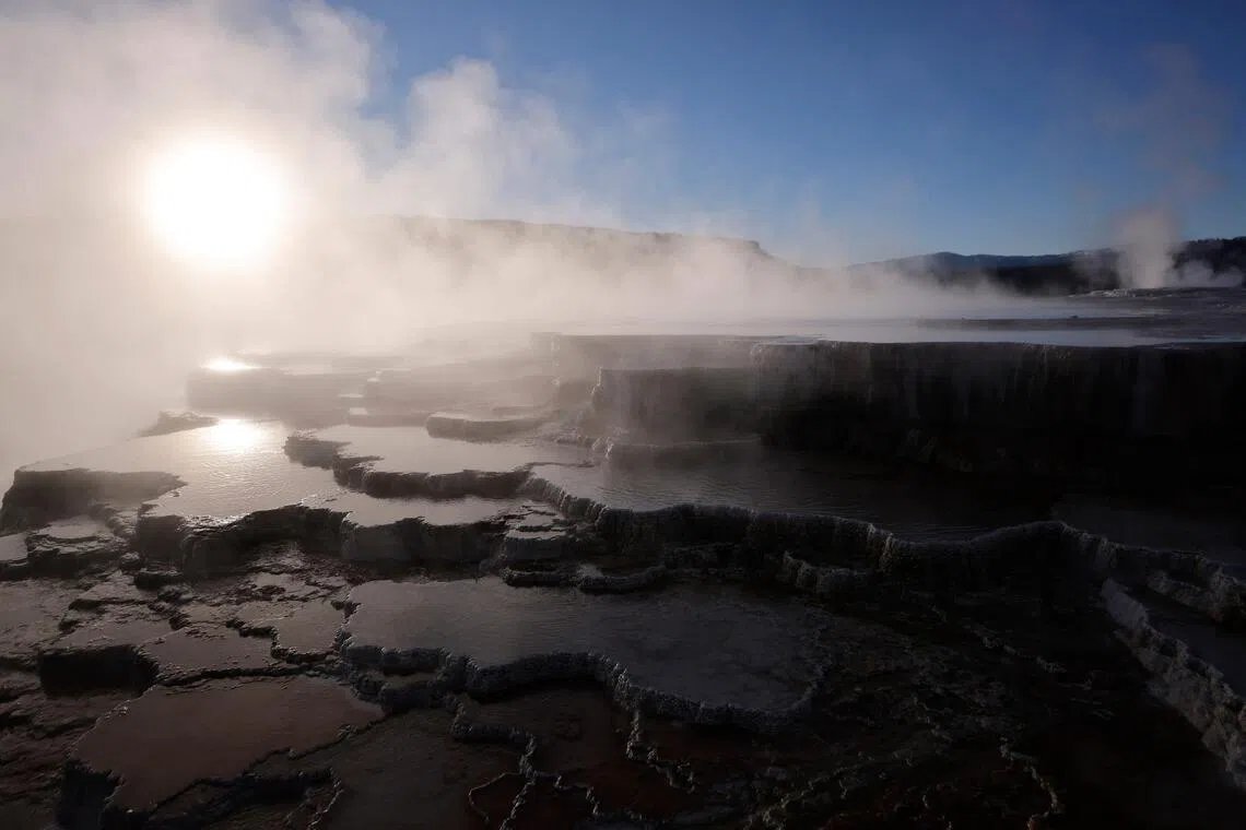 The sun rises above steam rising at Mammoth Hot Springs on May 19 in Yellowstone National Park. It has long been assumed the Sun would be engulfed by the expanding fireball of the dying Sun.