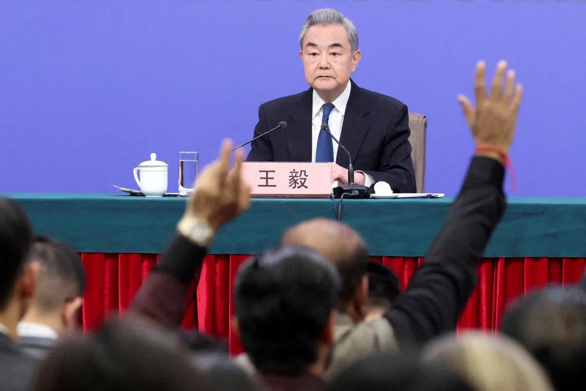 Members of the media raise hands to ask questions as Chinese Foreign Minister Wang Yi holds a press conference on the sidelines of the National People's Congress (NPC), in Beijing, China, March 8, 2026.