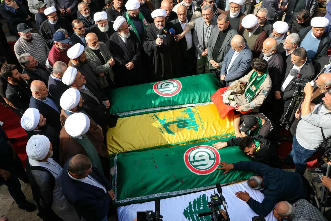 Mourners surround the caskets of four people killed in an overnight Israeli strike on the southern Lebanese village of Naqoura.