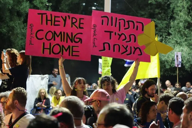 Women display placards during a gathering at Hostages Square in Tel Aviv on Oct 11, 2025. 