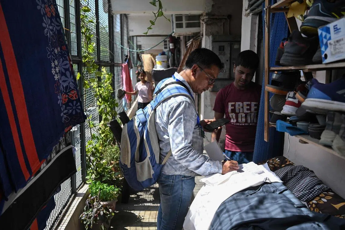 Lalit Verma, a census enumerator and school teacher, collects details of housing and amenities during a door-to-door survey in the first phase of the census at a residential area in New Delhi.
