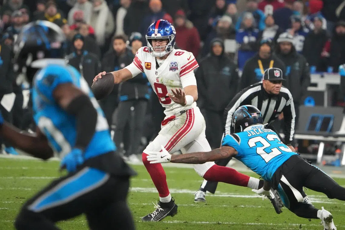 Nov 10, 2024; Munich, Germany; New York Giants quarterback Daniel Jones (8) is pressured by Carolina Panthers cornerback Dane Jackson (23) in the second half during the 2024 NFL Munich Game at Allianz Arena. Mandatory Credit: Kirby Lee-Imagn Images/ File Photo