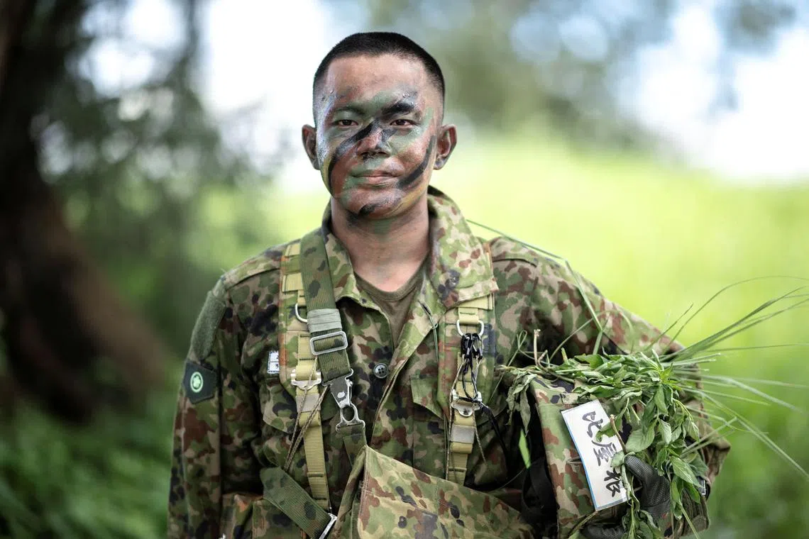 Takuma Hiyane, a newly-enlisted member of the Japan Ground Self-Defense Force (JGSDF), posing for a photograph following an exercise at JGSDF Camp Naha in Okinawa Prefecture on June 9, 2025.