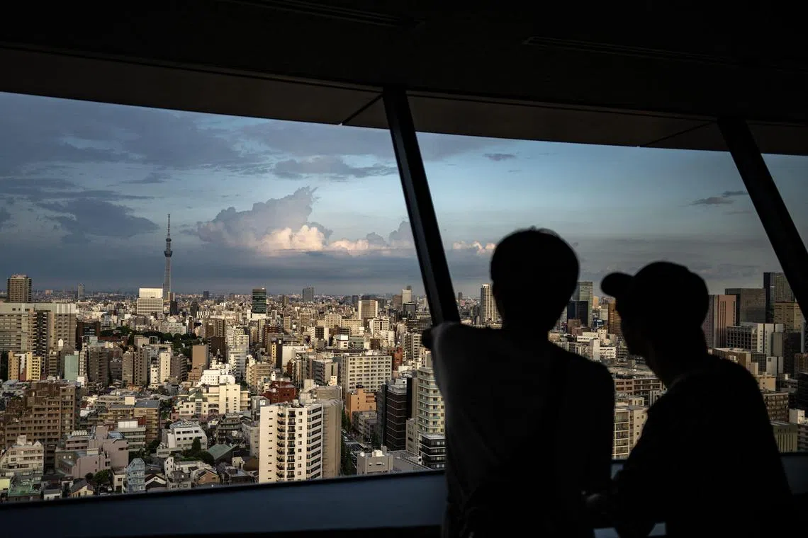 People look at the city's skyline from the Bunkyo Civic Centre Observation Deck in Tokyo on Aug 14.