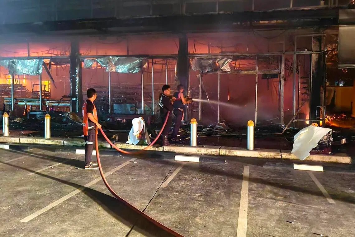 Firefighters extinguishing flames after a bomb explosion at a PTT petrol station in Narathiwat province, southern Thailand, early on Jan 11, 2026.