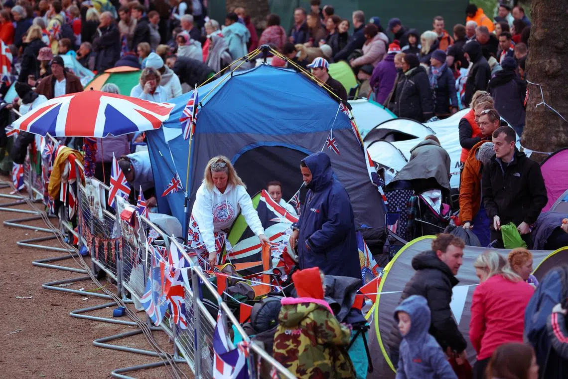 People waiting to watch Britain's King Charles' procession to his coronation ceremony from Buckingham Palace to Westminster Abbey, at The Mall in London, Britain May 6.