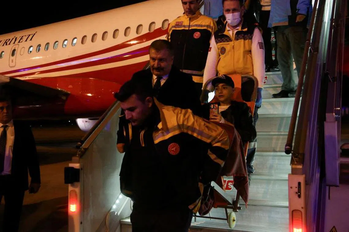 FILE PHOTO: Turkish Health Minister Fahrettin Koca walks as medical staff carry a Palestinian cancer patient who was evacuated from Gaza to Egypt and brought to Turkey by plane, at Esenboga Airport in Ankara, Turkey November 16, 2023. REUTERS/Cagla Gurdogan/File Photo