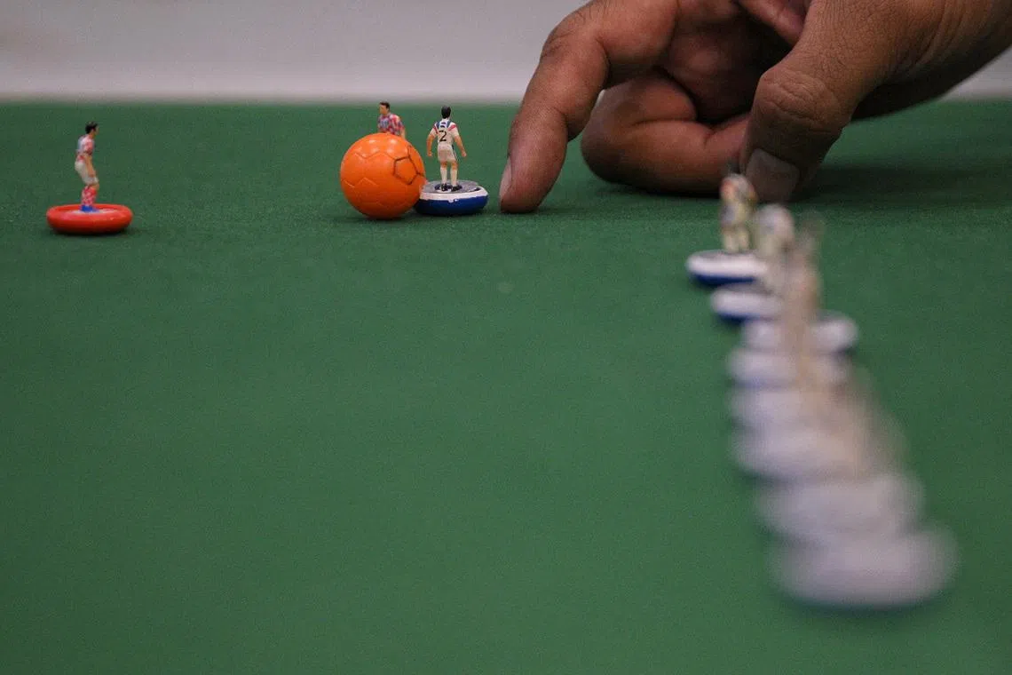 People play Subbuteo, a classic tabletop football game, at a community centre on June 18, 2026.
