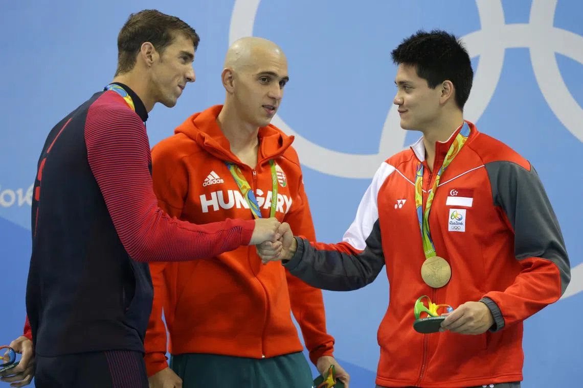 Michael Phelps (left) of United States congratulating Joseph Schooling (right) of Singapore, as Hungary's Laszlo Cseh (centre) looks on, on the podium after the men's 100m butterfly final in the Rio 2016 Olympic Games at the Olympic Aquatics Stadium in Rio de Janeiro, Brazil, on  Aug 12, 2016. Schooling beats Phelps and Cseh to win the gold medal in the event.