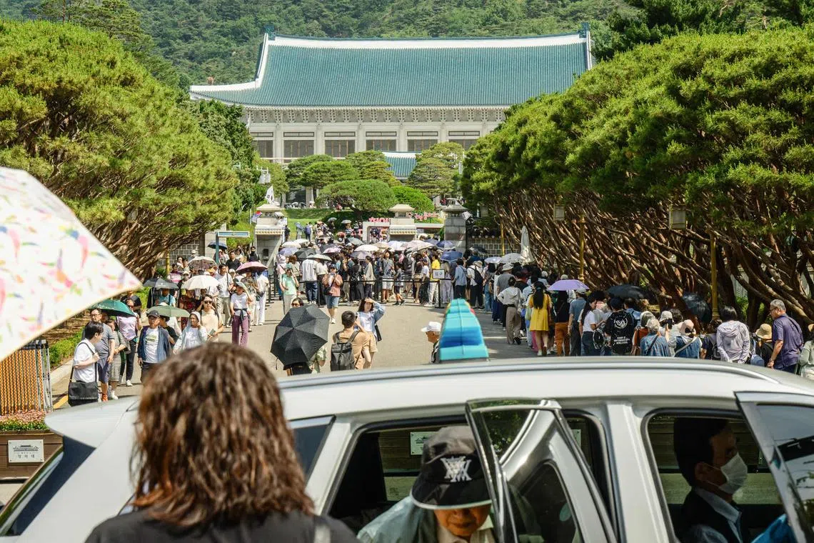 People queue up as they visit the Blue House in Seoul, named for the approximately 150,000 hand-painted blue tiles that adorn its roof.