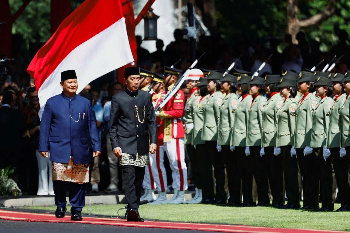 Indonesia's new President Prabowo Subianto and former President Joko Widodo walk as they inspect the honour guards during a handover ceremony at the Presidential palace in Jakarta, Indonesia October 20, 2024. REUTERS/Willy Kurniawan