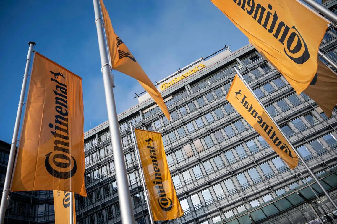 (FILES) Flags flutter in the breeze outside the facility of German auto parts manufacturer Continental AG, in Frankfurt am Main, western Germany on October 28, 2021. German auto supplier Continental said on February 14, 2024 it would cut some 7,150 posts worldwide by 2025 as the difficult switch to electric vehicles forces companies in the sector to retool. (Photo by Thomas Lohnes / AFP)