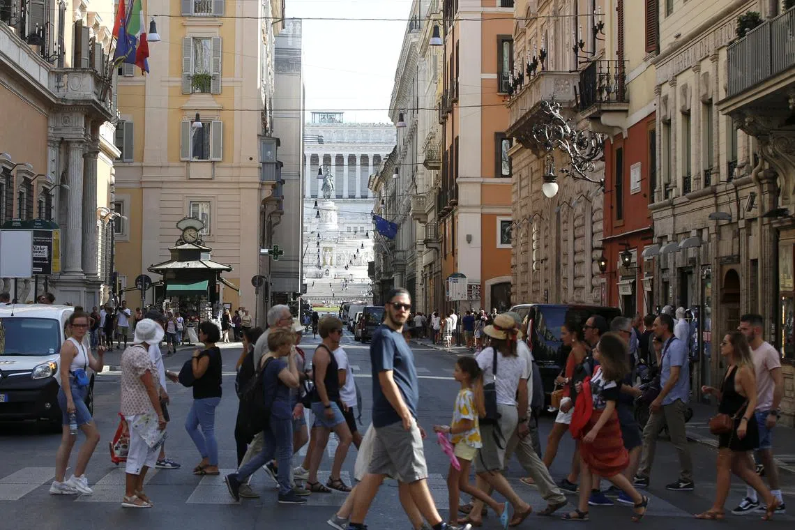 FILE PHOTO: People cross the street in Rome Italy, August 29, 2019. REUTERS/Ciro De Luca/ File Photo