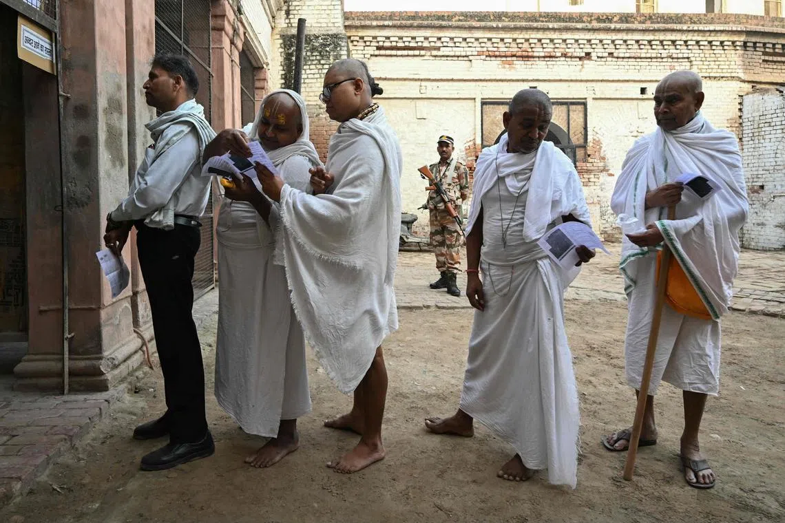 Voters queueing to cast their vote at a polling station during the second phase of voting of India's general elections in Vrindavan, on April 26, 2024. 