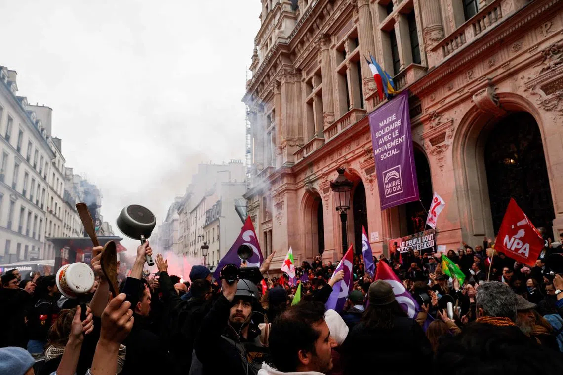 Demonstrators take part in a protest during French President Emmanuel Macron's televised address to the nation.