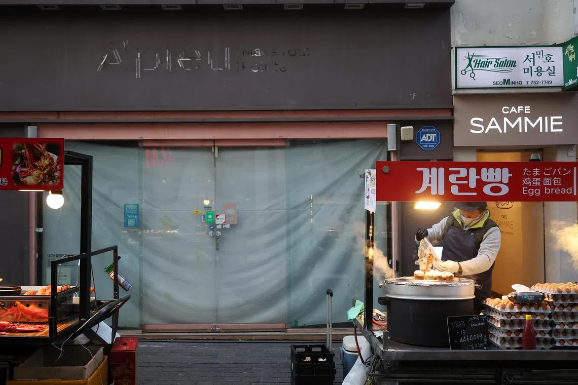 A street vendor waits for customers at the Myeongdong shopping district in Seoul on Jan 9, 2023.