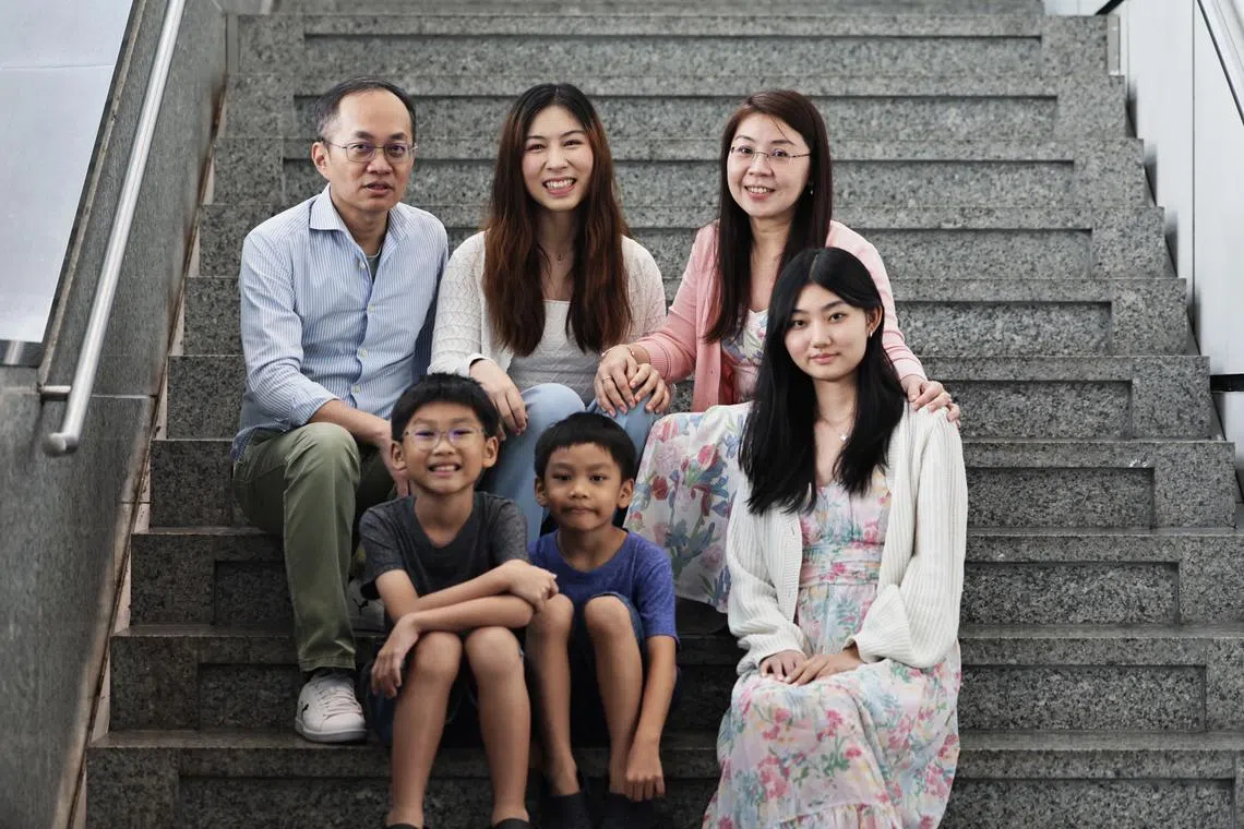 Ms Pauline Dominique Ching Alejado (back, centre) with her foster parents Mr Jason Gwee and Madam Irene Leow. Also pictured are the couple’s children – (from left) Joshua Gwee, Jairus Gwee and Chloe Gwee.