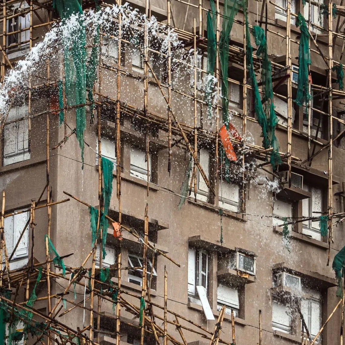 Firefighters hose down a smouldering residential building at the Wang Fuk Court in the Tai Po district of Hong Kong, China, on Thursday, Nov. 27, 2025. Hong Kong's worst residential fire in more than half a century has killed at least 44 people and left hundreds missing, throwing fresh scrutiny on the city's housing standards as Chinese President Xi Jinpingurges all-out efforts to reduce casualties. Photographer: Lam Yik/Bloomberg