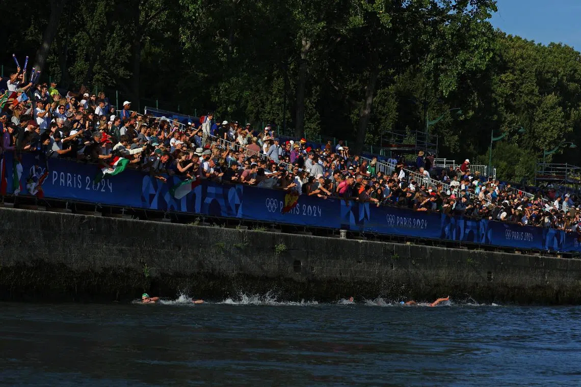 Spectators watching the men's marathon swimming race from the bank of the river Seine in Paris on Aug 9. 