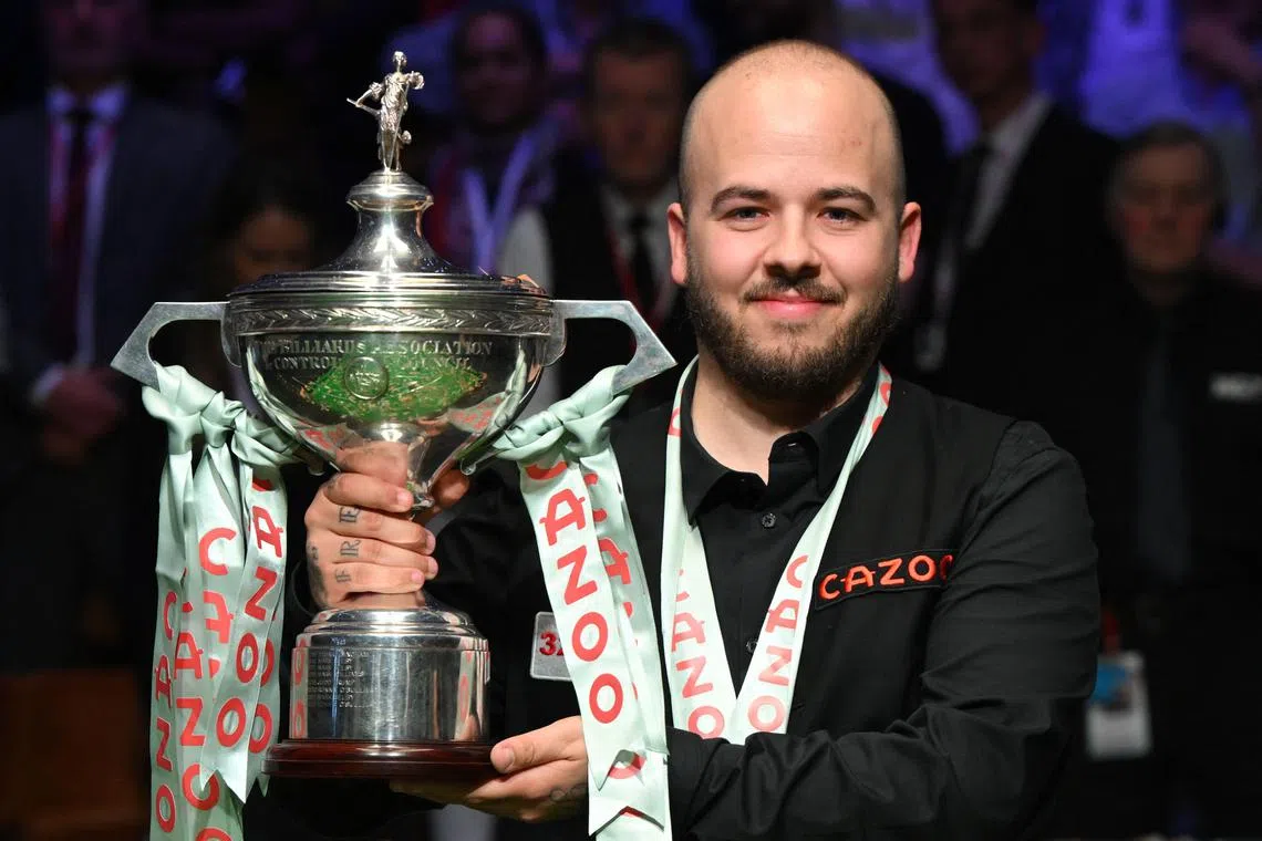 Belgium's Luca Brecel celebrating with the trophy after defeating England's Mark Selby the World Championship Snooker final at The Crucible in Sheffield, England.