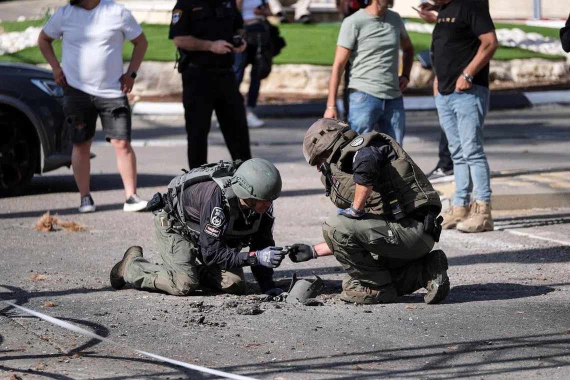 Israeli security personnel check the remains of a rocket in Shlomi, northern Israel.