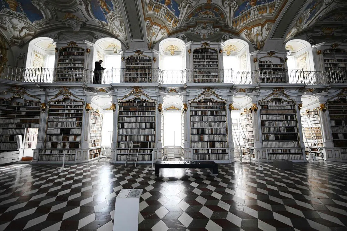 Father Maximilian Schiefermueller is seen in the library of the Benedictine Abbey in Admont, Austria on December 6, 2022. 
The Admont abbey library nestled amid the mountains of central Austria - which claims to be the largest monastic library in the world; has built a strong presence on social networks, with Baroque interiors attracting crowds of influencers and selfie hunters. The 70 metre-long hall is packed with 70,000 books. While it was opened in 1776, the oldest manuscripts date from the eighth century and were miraculously spared from a 1865 fire that engulfed much of the town and the monastery. 
