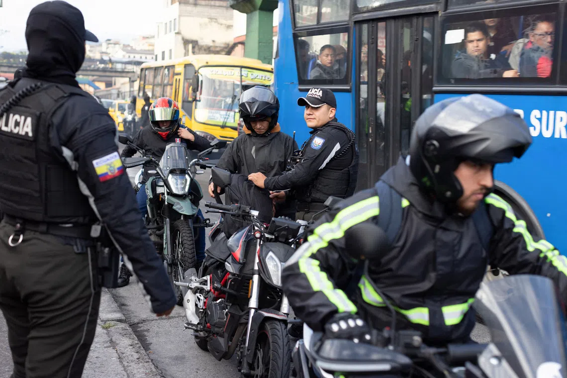 National Police officers search motorcyclists along a road in the San Roque neighborhood, as gangs gain a foothold in Ecuador's capital, in Quito, Ecuador, October 22, 2026. REUTERS/David Diaz Arcos