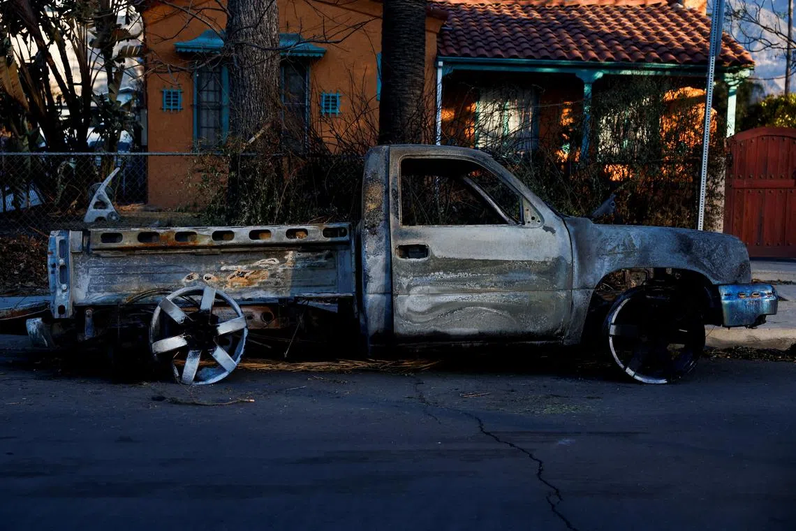 A burnt car is parked on a street, as the Eaton Fire continues, in Altadena, California, U.S. January 13, 2025. REUTERS/Shannon Stapleton