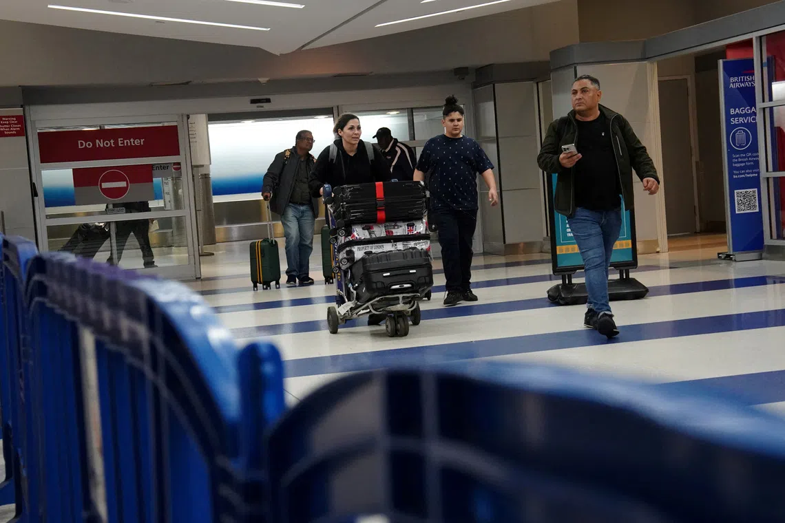 FILE PHOTO: Travelers arrive at Terminal 8 at John F. Kennedy International Airport in New York, U.S., June 8, 2025. REUTERS/Bing Guan/File Photo
