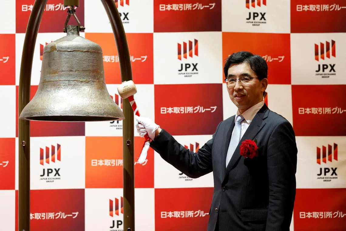 Rakuten Bank President Hiroyuki Nagai ringing a bell during a ceremony to mark the company's debut on the Tokyo Stock Exchange on April 21.