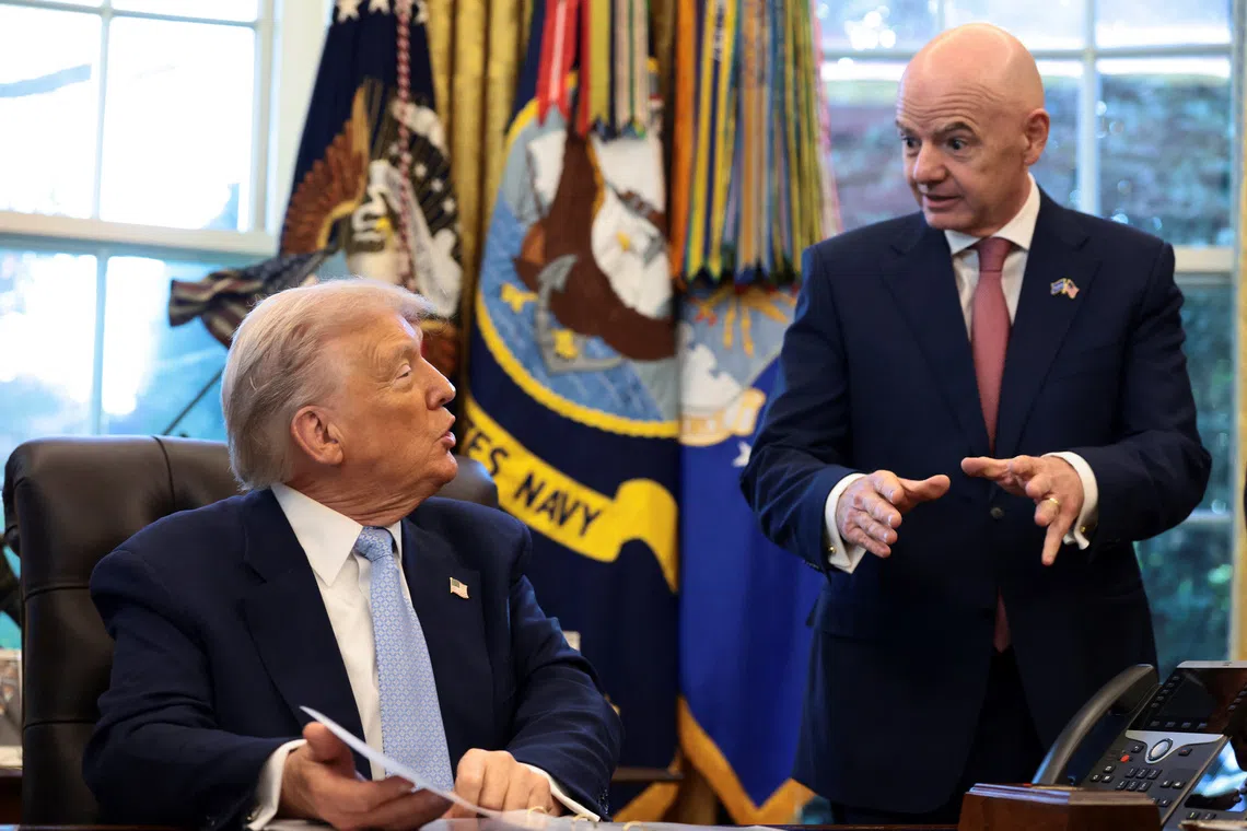 U.S. President Donald Trump sits next to FIFA President Gianni Infantino, as he meets with the White House Task Force on the FIFA World Cup 2026 in the Oval Office at the White House in Washington, D.C., U.S., November 17, 2025. REUTERS/Evelyn Hockstein