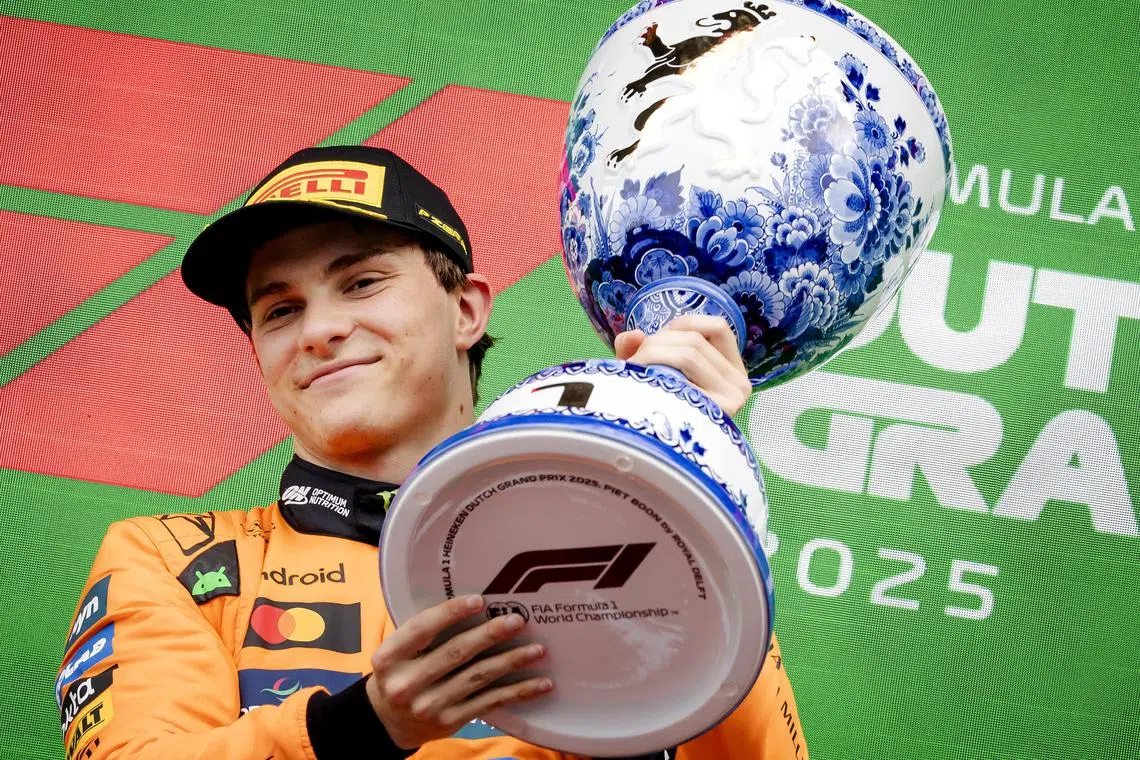 McLaren driver Oscar Piastri lifts his trophy after winning the Dutch Grand Prix at Zandvoort Circuit.