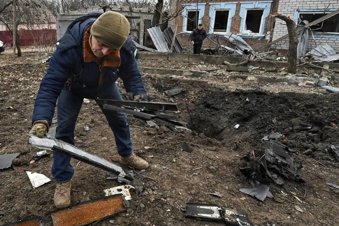 A man inspects parts of a kamikaze drone at a site of a residential area damaged by a Russian drone strike, amid Russia's attack on Ukraine, in Zaporizhzhia, Ukraine, on Nov 25.