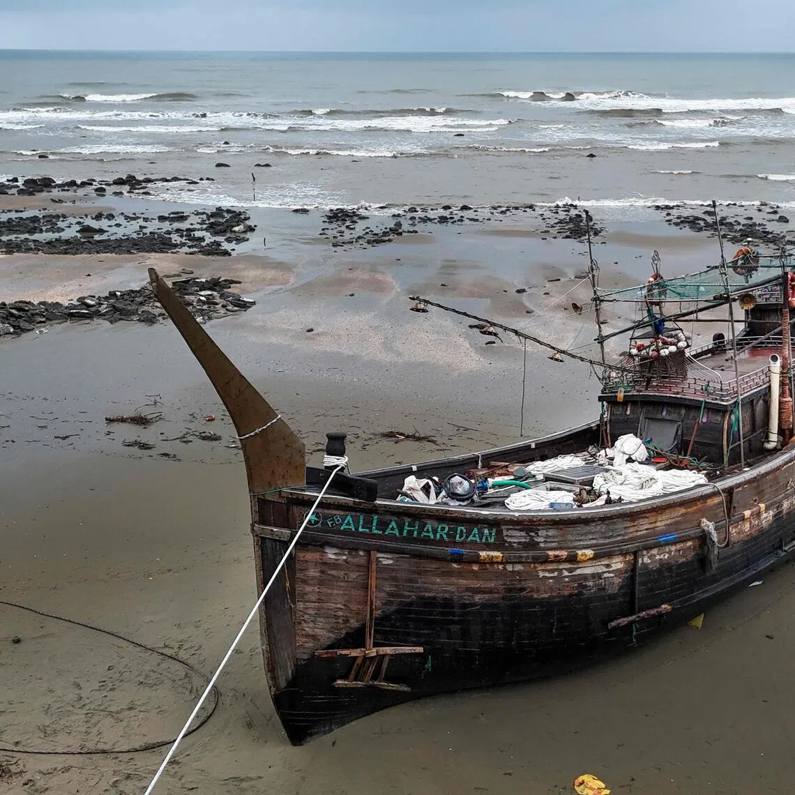 A suspected human trafficking boat lies stranded on the shore in Bangladesh’s Cox’s Bazar, on June 21.