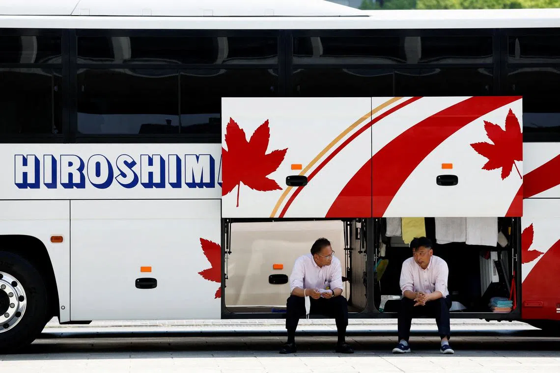 Tour bus drivers relax behind the Peace Memorial Museum, ahead of the G7 summit, in Hiroshima, Japan, May 17.